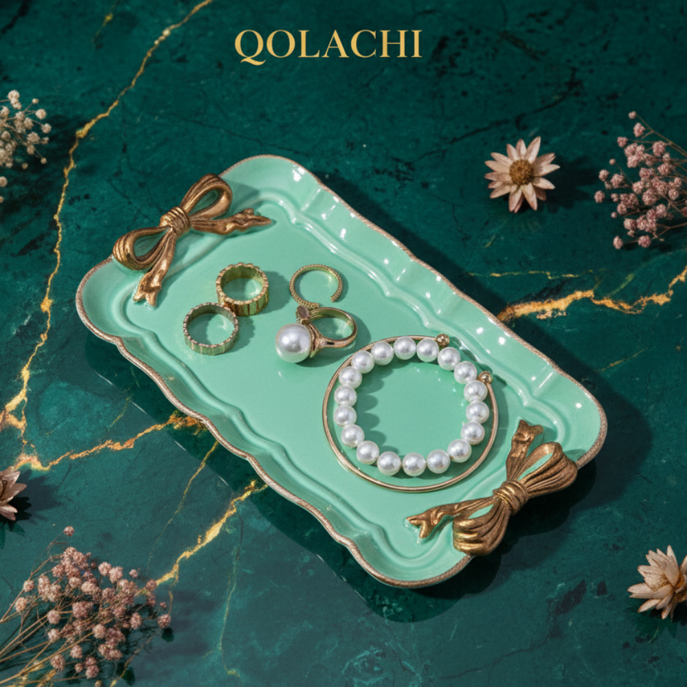 Qolachi mint bow jewelry tray on emerald marble background with golden streaks