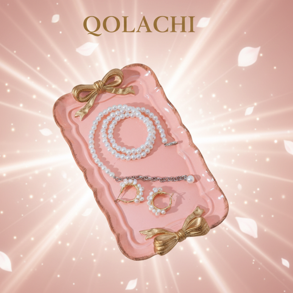Qolachi pink bow jewelry tray on rose gold gradient background with floating petals