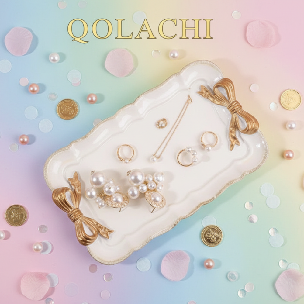 Qolachi pink bow jewelry tray flat lay on pastel rainbow background with pearls and rose petals
