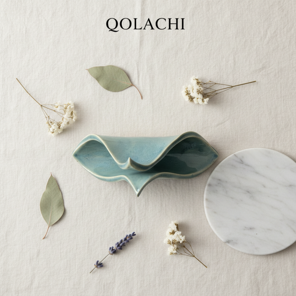 Qolachi Tidewwave ceramic napkin holder - flat lay on cream linen with botanicals